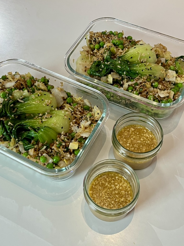 Rice with peas and bok choy in glass containers, with dressing in separate jars